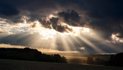 Wall Mural - rays of sun shining through dark clouds