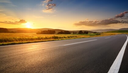 Canvas Print - empty asphalt road in a rural landscape at sunset