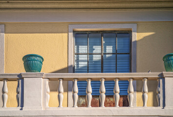 White Balcony with Teal Vases on a Yellow Building.