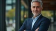 © The Little Hut - Portrait of mature grayhaired businessman senior boss smiling and looking at camera with arms crossed grayhaired man outside office building successful investor and owner in business s : Generative AI
