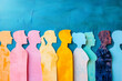 ©  Studio AB Images - Creative background of diversity and equity. Colourful silhouettes of diverse people in cut-out paper art style on blue background.