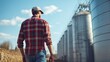 © The Little Hut - Male farmer walking along silos on sunny farm : Generative AI