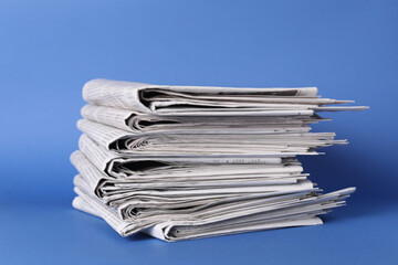 Canvas Print - Stack of many newspapers on blue background