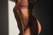 © blackday - Natural fit woman's torso with stretch marks on her thighs, highlighted by sunlight