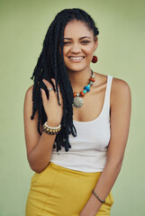 Poster - Fashion, dreadlocks and happy woman in studio with casual, cool and trendy outfit for confidence. Portrait, smile and person with traditional jewelry for accessory with clothes by green background.