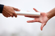 © Nina2024/peopleimages.com - Running, fitness and hands with baton for relay on track for training, marathon exercise and workout. Sports, athlete and people for performance, endurance and challenge for competition closeup