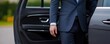 © Wasana - Chauffeur in a luxury car opening the door for a guest, sleek vehicle interior, high-end service