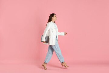 Wall Mural - Beautiful woman in stylish white jacket with laptop on pink background