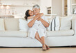 © peopleimages.com - Love, grandma and grandchild with kiss on sofa with hugging, weekend visit and bonding in house. Happy family, senior woman and girl kid with embrace on couch in living room with support and care