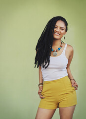 Poster - Confident, style and portrait of woman in studio for summer clothes, accessories and trendy outfit. Happy, smile and female person with dreadlocks on green background for fashion, jewellery and pride