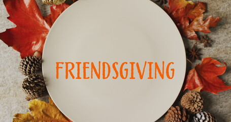 Wall Mural - image of friendsgiving text over cutlery and autumn leaves over grey background