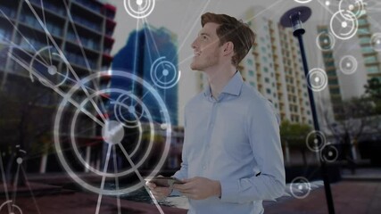 Wall Mural - Holding tablet, man surrounded by digital network connections animation over cityscape