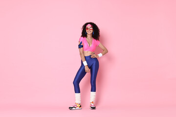 Wall Mural - Aerobics. Happy woman in sportswear on pink background