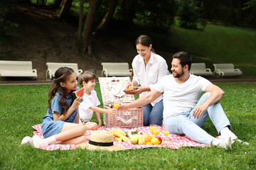 Wall Mural - Happy family having picnic together in park