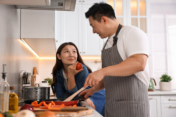 Wall Mural - Happy lovely couple cooking together in kitchen