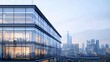 © venusvi - Modern office building exterior with glass windows and urban skyline in the background