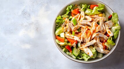 Wall Mural - A vibrant bowl of buffalo chicken salad featuring shredded chicken, crisp lettuce, and colorful vegetables, beautifully arranged on a light solid color background