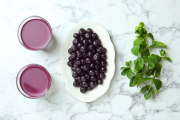 Poster - Tasty fresh acai juice in glasses, mint and berries on white marble table, flat lay