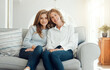 © peopleimages.com - Mature mother, daughter and happy on sofa at home for care, bonding and support in England. People, family and smile or laugh on couch in living room on break for unity, relax and trust on portrait