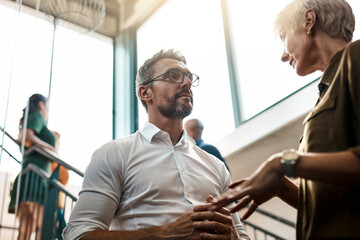 Wall Mural - Office, support and business people in meeting with discussion for advice, feedback and hiring plan. Low angle, job and HR manager with conversation on stairs for recruitment, decision or onboarding