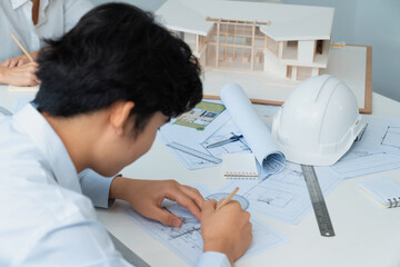 Wall Mural - Professional engineer measures house model while skilled interior designer taking a note. Work together, collaboration, cooperative. Creative design and team working concept. Top view. Immaculate.