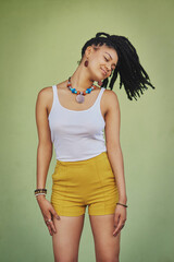 Canvas Print - Fashion, dreadlocks and woman in studio with casual, cool and trendy outfit for confidence. Calm, smile and female person with traditional jewelry for accessory with clothes by green background.