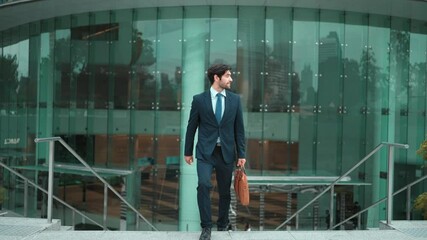 Wall Mural - Happy smart business man dancing to celebrate good news about getting promotion, increasing sales, increasing salary while walking up stairs with blurring background at city. Lively mood. Exultant.