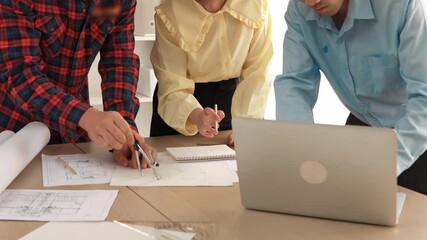 Wall Mural - Architect and safety engineer discussion about building blueprint displaying on laptop on table using architectural document and measurement tool for accuracy at modern office. Closeup. Delineation.