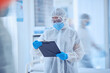 © Azee Jacobs/peopleimages.com - Doctor, ppe and person with medical report in hospital for mpox pandemic treatment protocol. Mask, protective suit and scientist with document for health, research or busy reading clipboard with blur