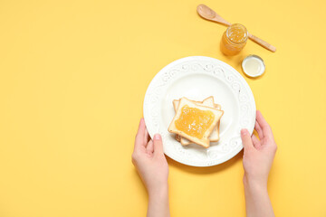 Sticker - Female hands with plate of tasty toasts and jam on color background