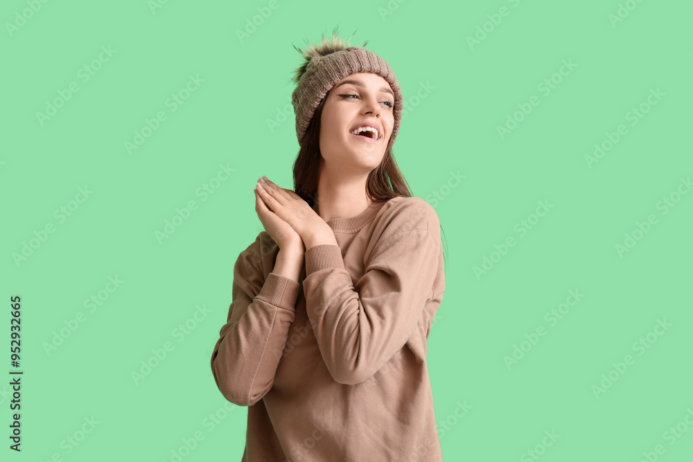 Young woman in winter clothes on green background