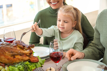 Sticker - Little girl with her parents having dinner at festive table on Thanksgiving Day, closeup