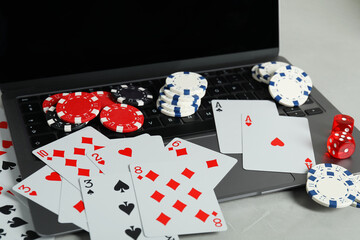 Sticker - Online poker. Playing cards, chips, dice and laptop on light grey table