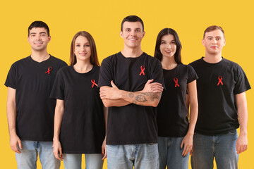 Poster - Group of young people with red ribbons on yellow background. World AIDS day concept