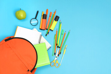 Poster - Backpack and different school supplies on light blue background, flat lay. Space for text