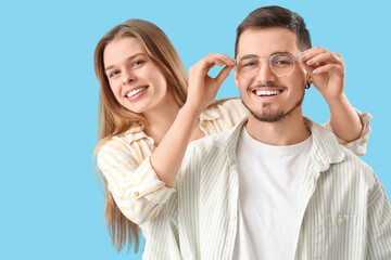 Young couple with eyeglasses on blue background