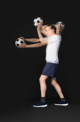 Wall Mural - Handsome soccer throwing ball in motion on black background