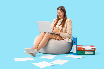 Sticker - Young pregnant businesswoman working with laptop on blue background