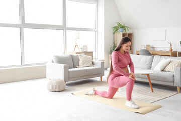 Canvas Print - Sporty pregnant woman training on fitness mat at home