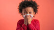 © Nemanja - A young African American boy kid blowing his nose into a tissue, challenges of dealing with allergy and influenza illness during the cold winter fever infection season