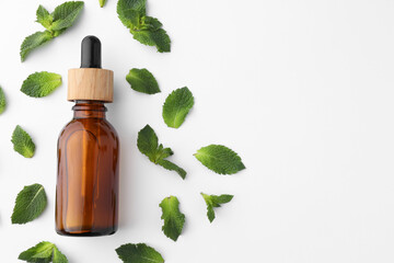 Wall Mural - Bottle of essential oil and mint isolated on white, top view