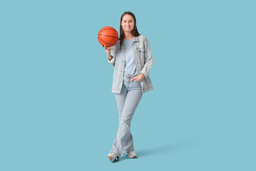 Canvas Print - Portrait of pretty young woman with basketball on blue background