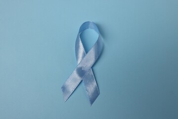 Wall Mural - Light blue ribbon on color background, top view. Prostate cancer awareness