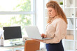 © Pixel-Shot - Young businesswoman using modern laptop near workplace in office