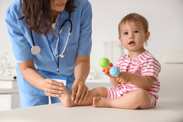 Sticker - Female pediatrician with stethoscope, toy and cute little baby in clinic