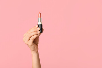 Wall Mural - Female hand with lipstick on pink background