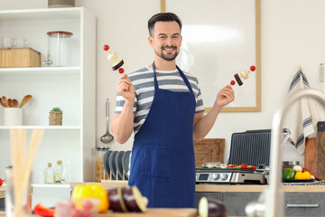 Sticker - Young happy man cooking tasty fresh vegetables skewers near modern electric grill in kitchen