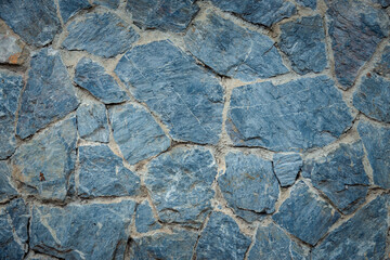 Wall Mural - A wall made of blue stones. The stones are rough and uneven