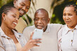 © Flashizzle/peopleimages.com - Man, woman and senior parents with phone checking modern technology, social media or news. Smartphone, photography and black family with mobile app for digital memory, online search or home bonding