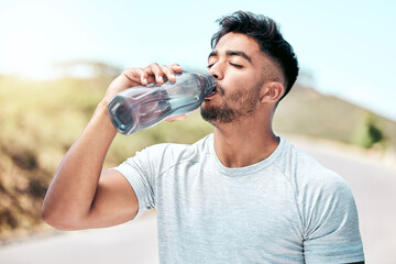 Wall Mural - Fitness, man and drinking water in nature for health, wellness an hydration in day. Thirsty, liquid and athlete with bottle for detox, natural nutrition and minerals on road for exercise and training